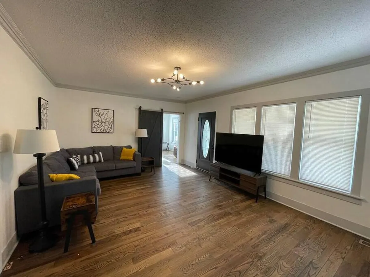 A cozy living room featuring a sofa, television, lamp, and artwork. The space exudes warmth and comfort, making it a welcoming area for quiet moments, relaxed reading, or family storytelling.
