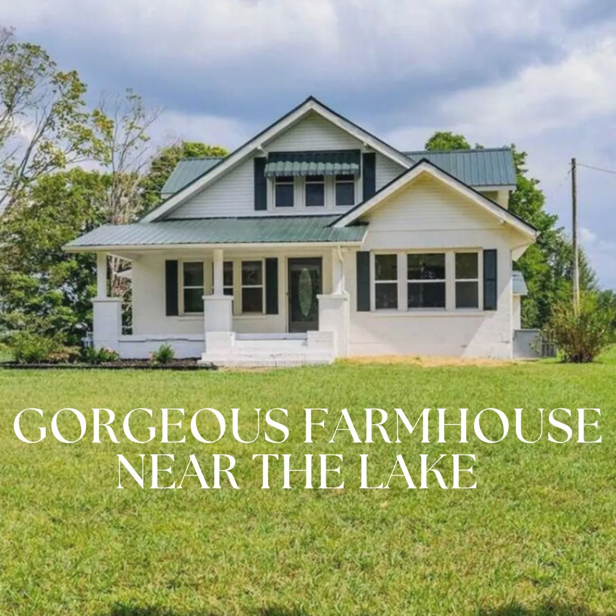 A charming farmhouse with a green roof and a spacious front porch, set against a peaceful landscape that hints at proximity to the lake. The porch invites relaxation, and the scene suggests easy access to outdoor adventures and tranquil moments enjoying nature.